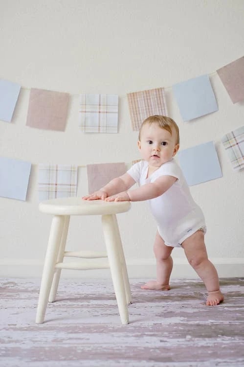 Curious Baby Exploring A White Stool